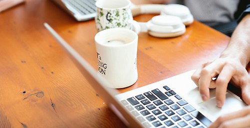 En person sitter framför en dator.